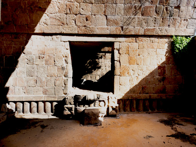 Vista lateral de estructuras mayas en Kabah entre vegetación